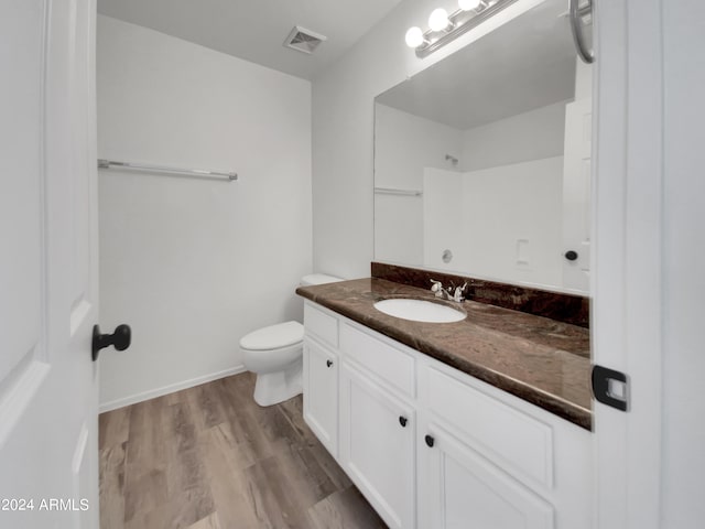 bathroom with hardwood / wood-style flooring, toilet, and vanity