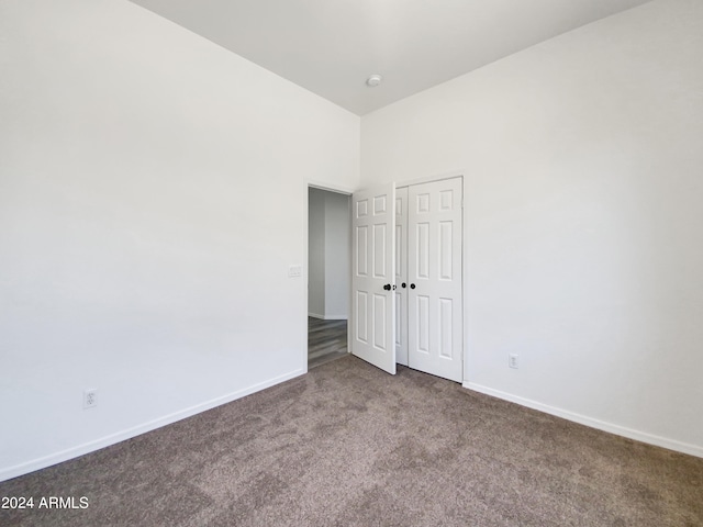 spare room with dark carpet