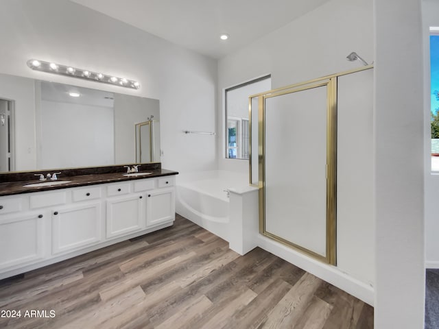 bathroom with plenty of natural light, hardwood / wood-style flooring, double vanity, and shower with separate bathtub