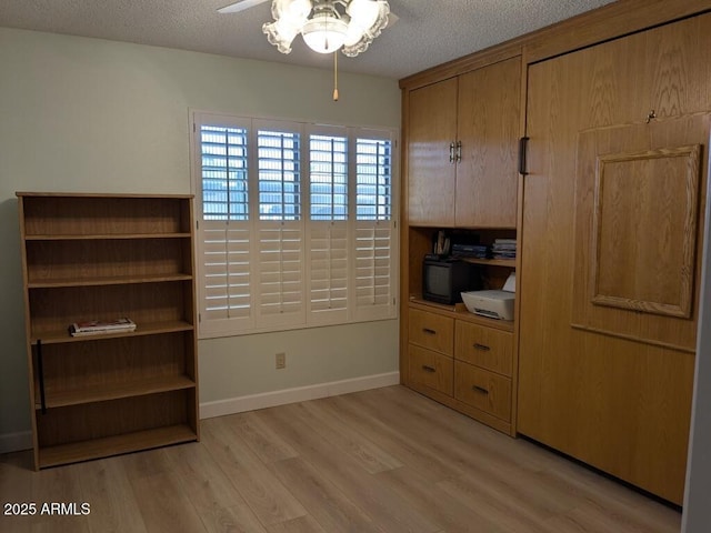 office space featuring light wood-type flooring, ceiling fan, a textured ceiling, and baseboards