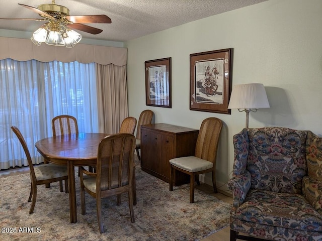 dining space featuring a textured ceiling and a ceiling fan