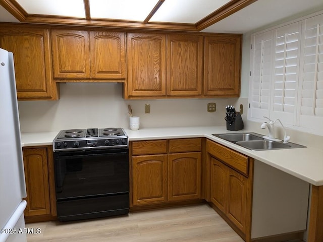 kitchen featuring light countertops, black range with electric cooktop, a sink, and brown cabinetry