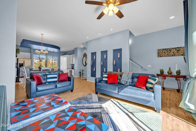 living room featuring light hardwood / wood-style floors and ceiling fan with notable chandelier