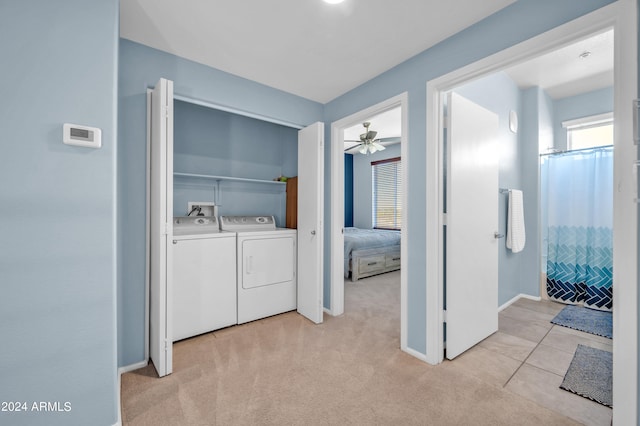 laundry area with washer and dryer, light colored carpet, and ceiling fan