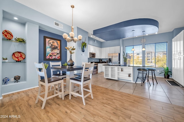 dining room featuring light hardwood / wood-style flooring and an inviting chandelier