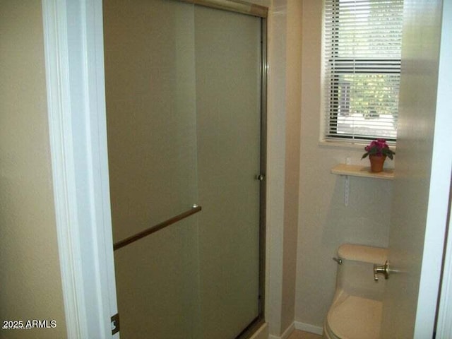 bathroom with walk in shower and toilet