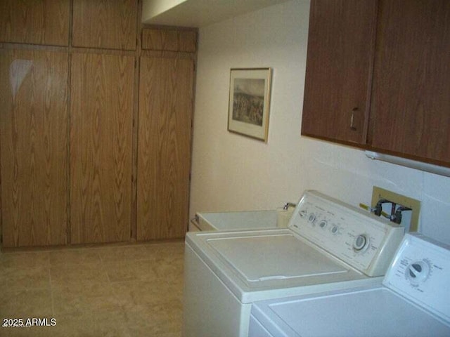 laundry room with washing machine and dryer and cabinets