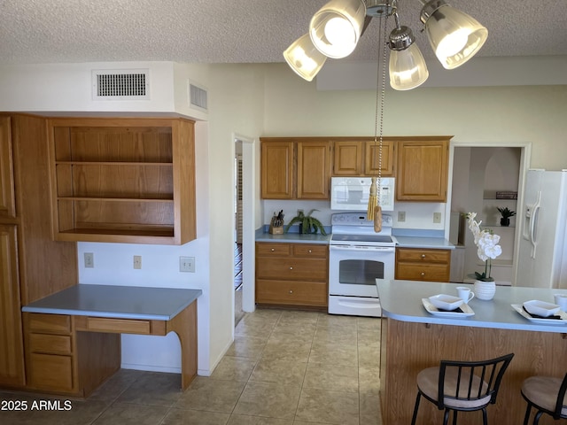 kitchen with a kitchen bar, a textured ceiling, white appliances, and light tile patterned flooring