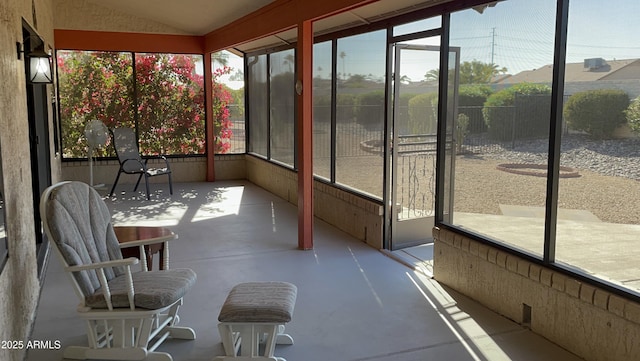 unfurnished sunroom featuring vaulted ceiling