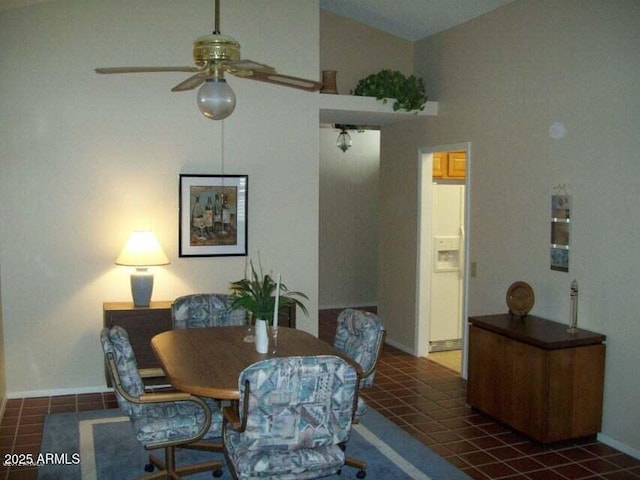 tiled dining room featuring ceiling fan and high vaulted ceiling