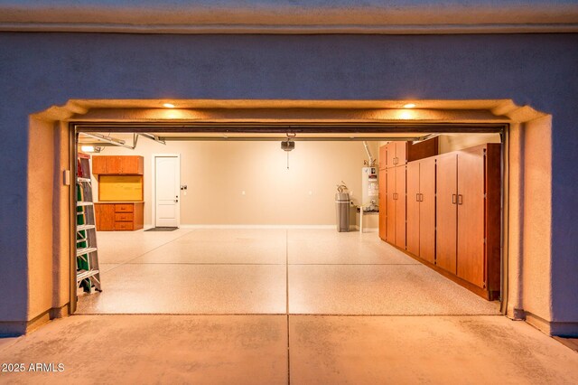 garage featuring water heater and baseboards