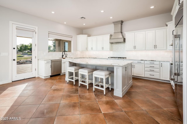 kitchen featuring a kitchen island, visible vents, tasteful backsplash, dishwasher, and custom exhaust hood
