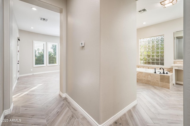 corridor featuring baseboards and visible vents