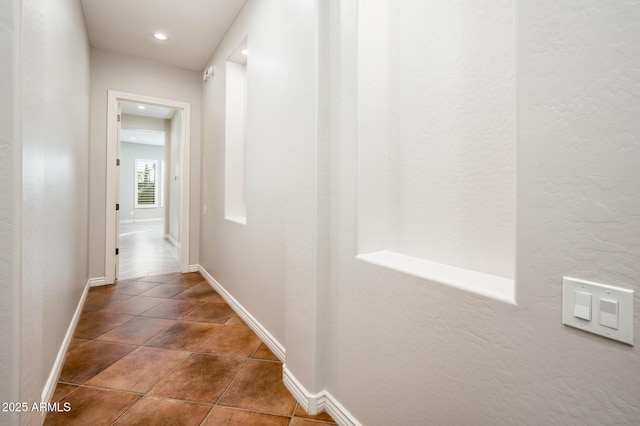 corridor with baseboards, recessed lighting, and tile patterned floors