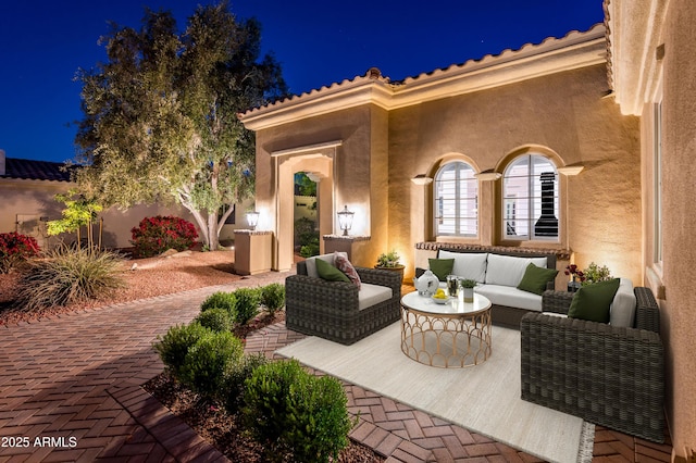 patio at night featuring an outdoor living space