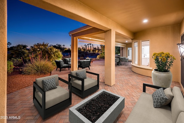 view of patio / terrace with outdoor dining space and an outdoor living space with a fire pit