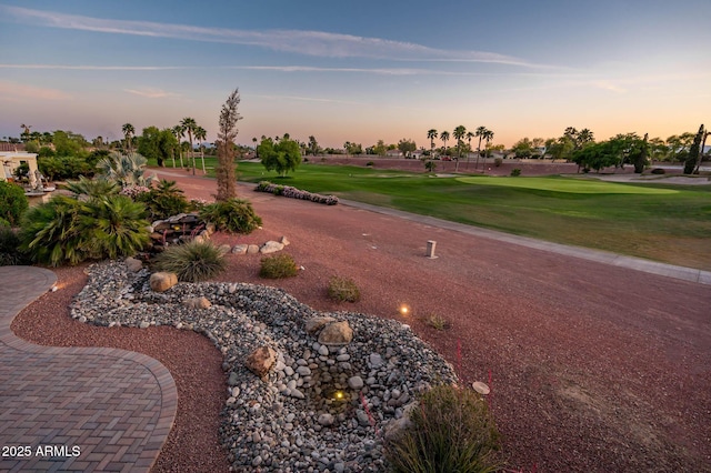 view of home's community with golf course view and a yard