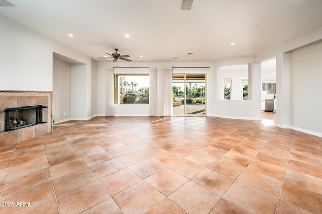 unfurnished living room featuring baseboards, ceiling fan, recessed lighting, a tiled fireplace, and light tile patterned floors