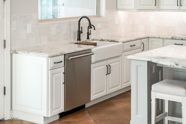 kitchen with tile patterned flooring, light stone countertops, white cabinetry, and dishwasher