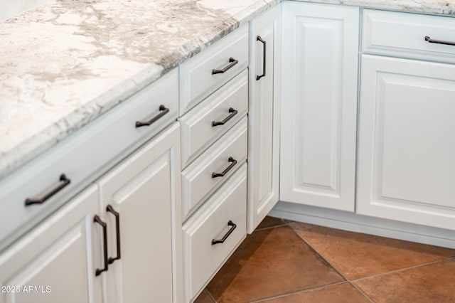 details with white cabinets and light stone countertops