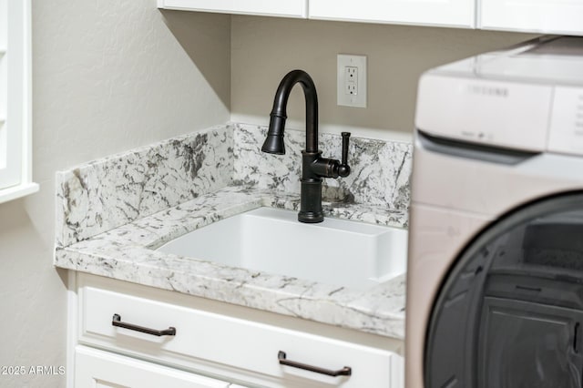 details featuring a sink and washer / clothes dryer