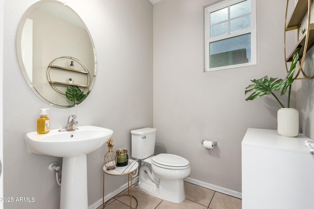 bathroom with toilet, tile patterned flooring, and sink