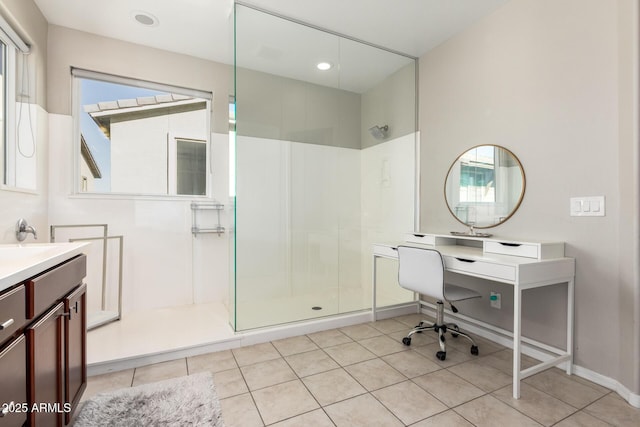 bathroom featuring tile patterned floors, a shower with door, and vanity