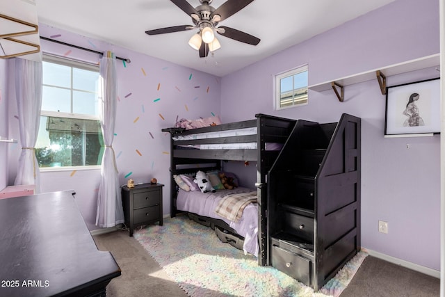 carpeted bedroom with ceiling fan and multiple windows