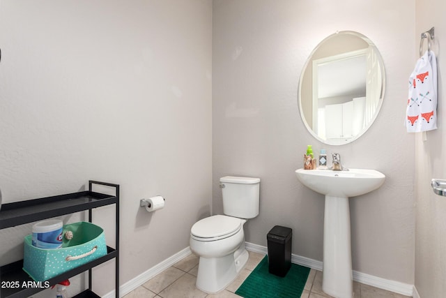 bathroom featuring toilet, sink, and tile patterned floors