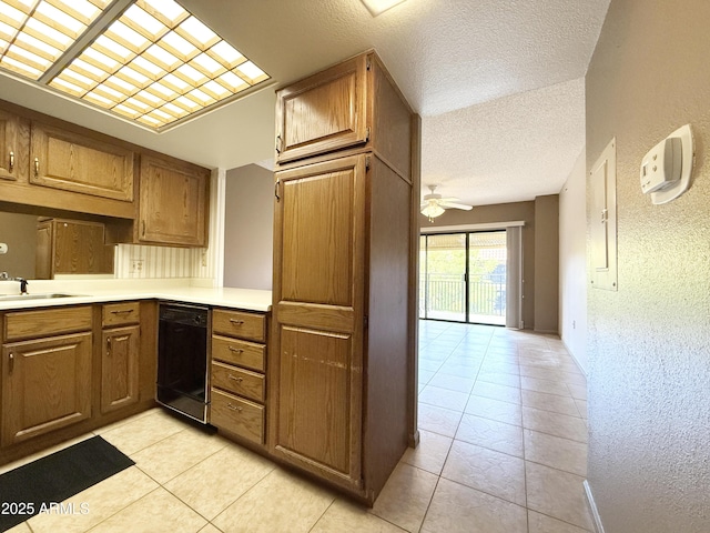 kitchen featuring sink, a textured ceiling, light tile patterned floors, dishwasher, and ceiling fan