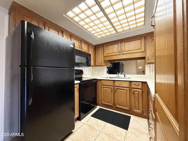 kitchen with sink, black appliances, and light tile patterned flooring