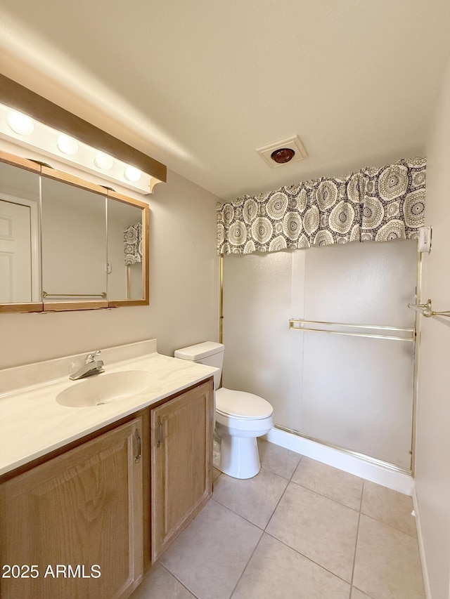 bathroom featuring vanity, tile patterned floors, and toilet