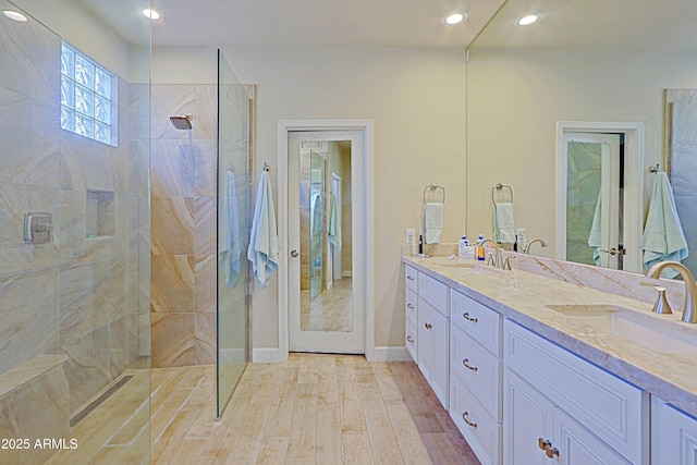 full bathroom with walk in shower, a sink, double vanity, recessed lighting, and wood finished floors