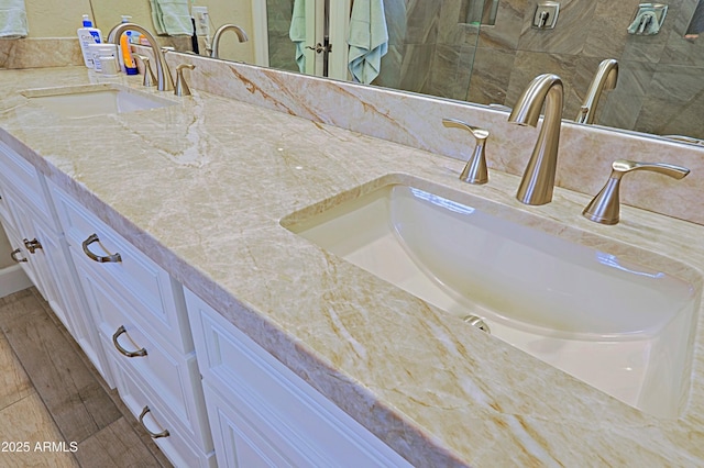 bathroom featuring double vanity, a sink, and wood finished floors