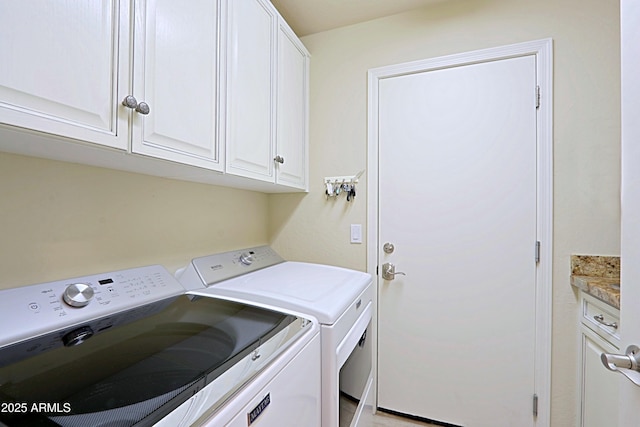washroom featuring separate washer and dryer and cabinet space