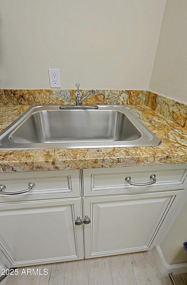 interior details featuring light countertops, a sink, and light wood-type flooring