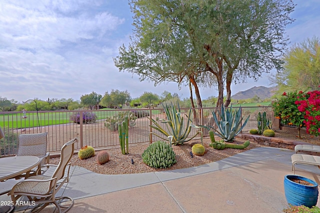 view of patio / terrace with a fenced backyard, a mountain view, and outdoor dining space