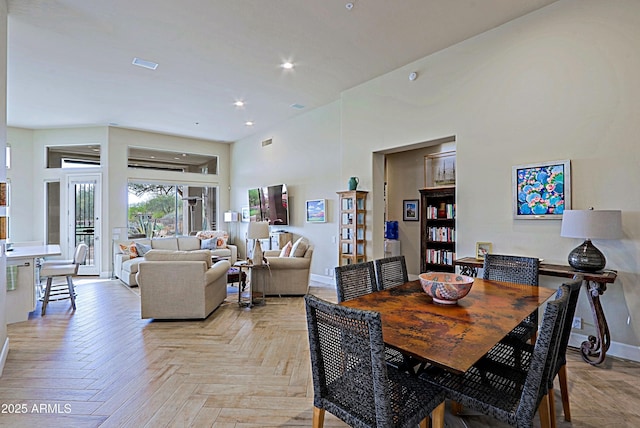 dining space with recessed lighting, baseboards, visible vents, and a high ceiling