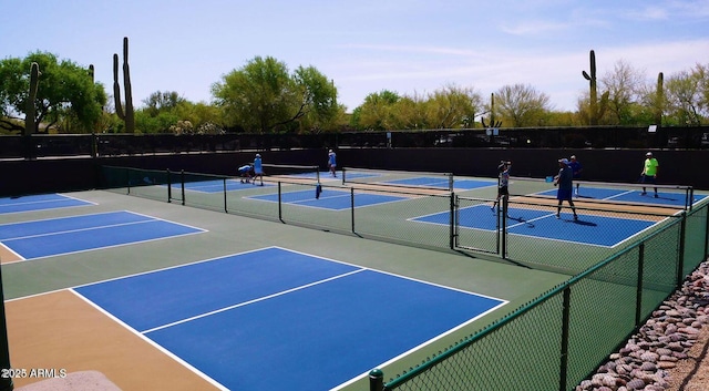 view of tennis court featuring fence and community basketball court