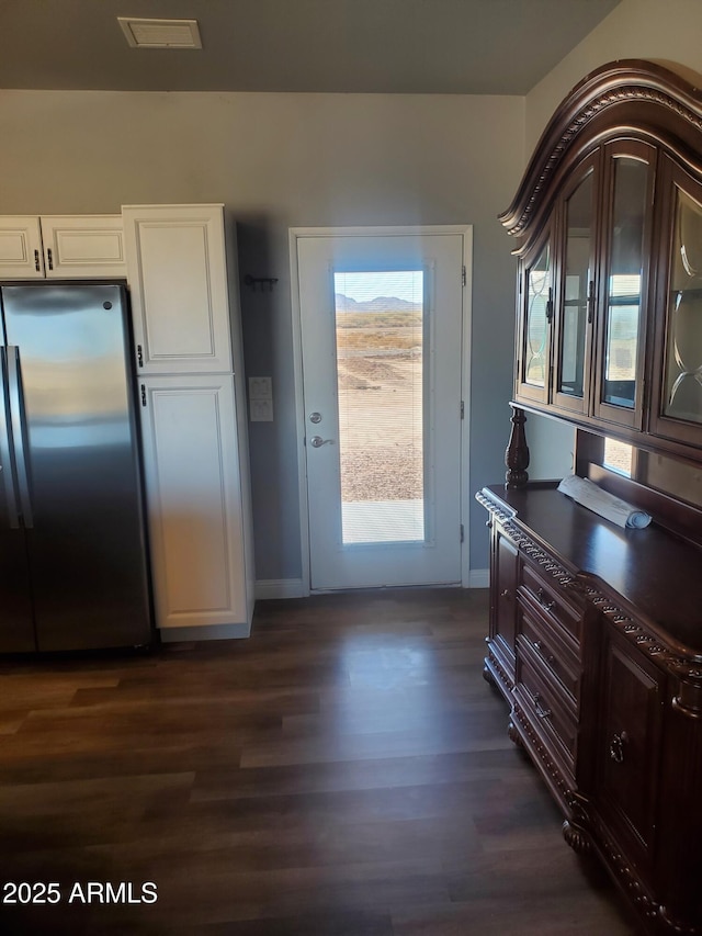 entryway with dark wood-style floors and baseboards