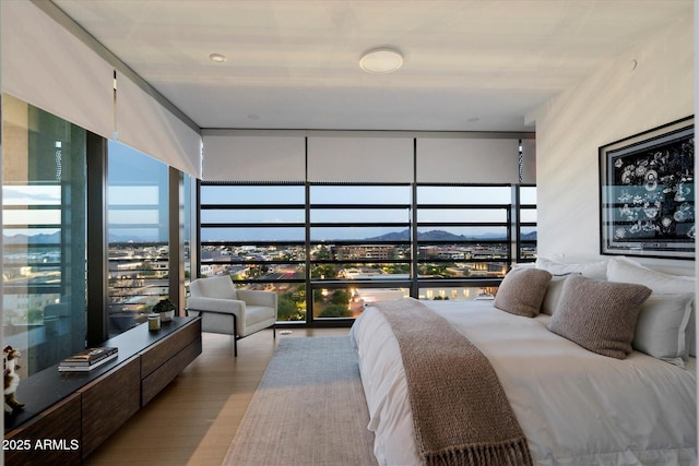 7180 E Kierland Blvd Unit 1116, Scottsdale, AZ 85254 - bedroom featuring floor to ceiling windows, a mountain view, multiple windows, and wood finished floors