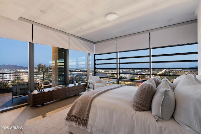 7180 E Kierland Blvd Unit 1116, Scottsdale, AZ 85254 - bedroom featuring wood finished floors, a view of city, a mountain view, and expansive windows