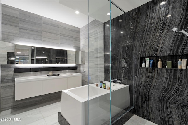 7180 E Kierland Blvd Unit 1116, Scottsdale, AZ 85254 - full bathroom featuring tile walls, a freestanding tub, vanity, and a shower stall