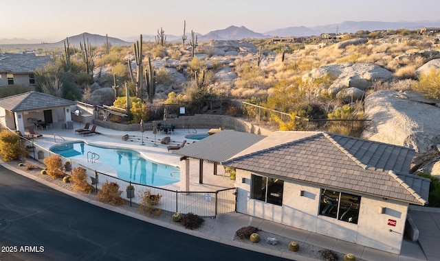 pool at dusk with a mountain view and a patio