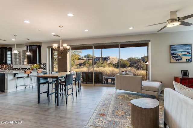 dining room featuring sink and ceiling fan with notable chandelier