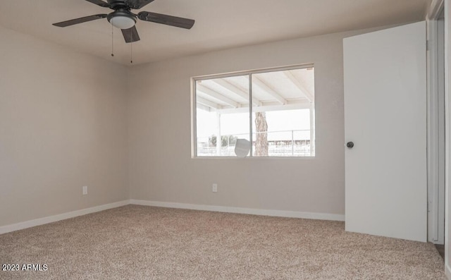 carpeted spare room featuring ceiling fan