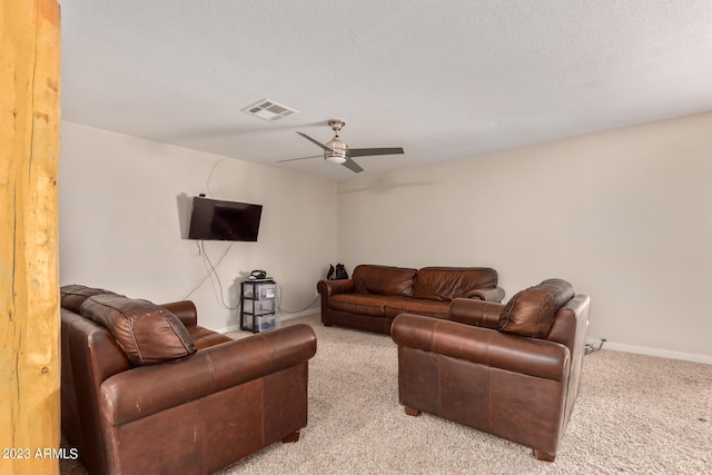 living room featuring light colored carpet, ceiling fan, and a textured ceiling