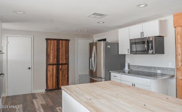 kitchen with appliances with stainless steel finishes, wooden counters, dark hardwood / wood-style floors, and white cabinets