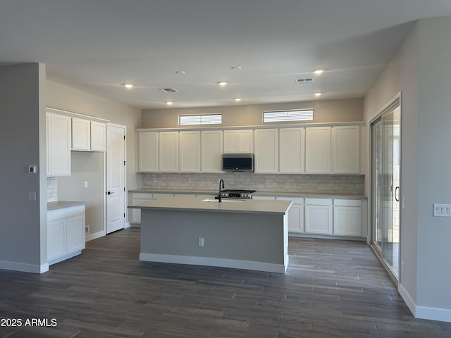 43471 N Wollemi St, Queen Creek, AZ 85140 - kitchen with stainless steel microwave, decorative backsplash, light countertops, white cabinetry, and a sink