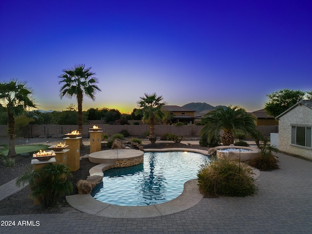 pool at dusk featuring a patio area